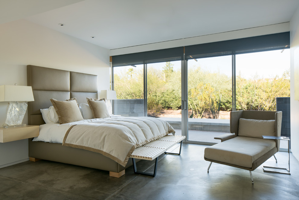 Immagine di una camera da letto contemporanea con pareti bianche, pavimento in cemento e pavimento grigio