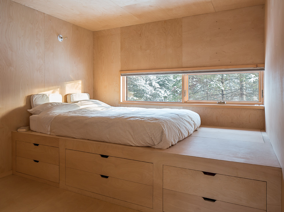 This is an example of a small rustic mezzanine bedroom in Montreal with light hardwood flooring.