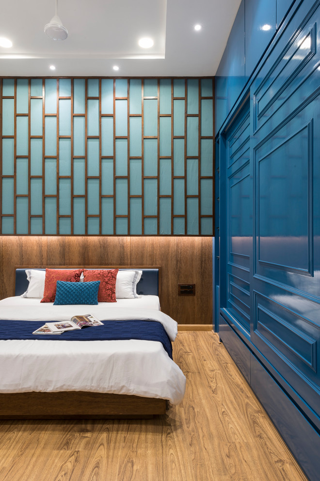 Inspiration för moderna sovrum, med blå väggar, mellanmörkt trägolv och brunt golv