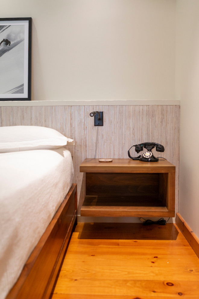 Ejemplo de dormitorio principal rústico grande sin chimenea con paredes blancas, suelo de madera en tonos medios y suelo naranja