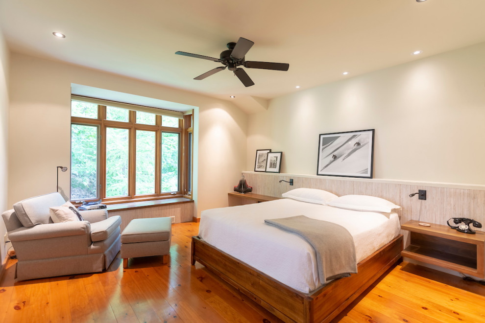 Imagen de dormitorio principal rural grande sin chimenea con paredes blancas, suelo de madera en tonos medios y suelo naranja