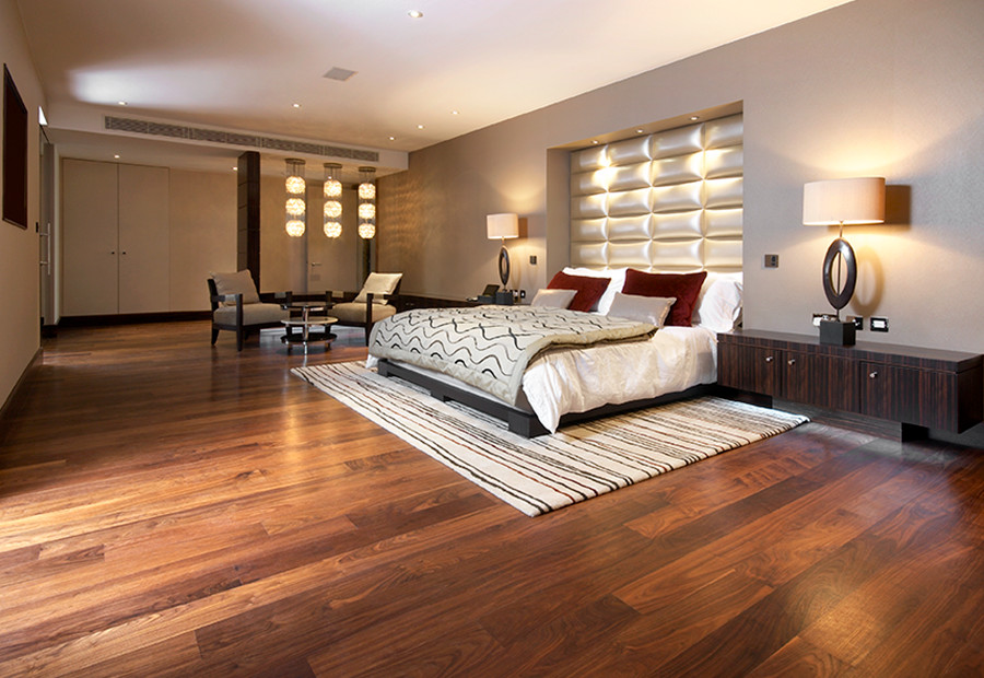 Photo of an expansive contemporary mezzanine bedroom in London with beige walls and medium hardwood flooring.