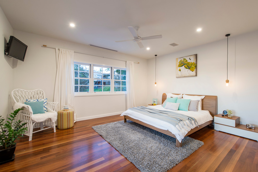 Imagen de dormitorio principal actual con paredes blancas y suelo de madera en tonos medios