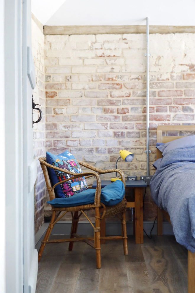 Mittelgroßes Maritimes Hauptschlafzimmer mit bunten Wänden, braunem Holzboden, braunem Boden, gewölbter Decke und Ziegelwänden in Sussex