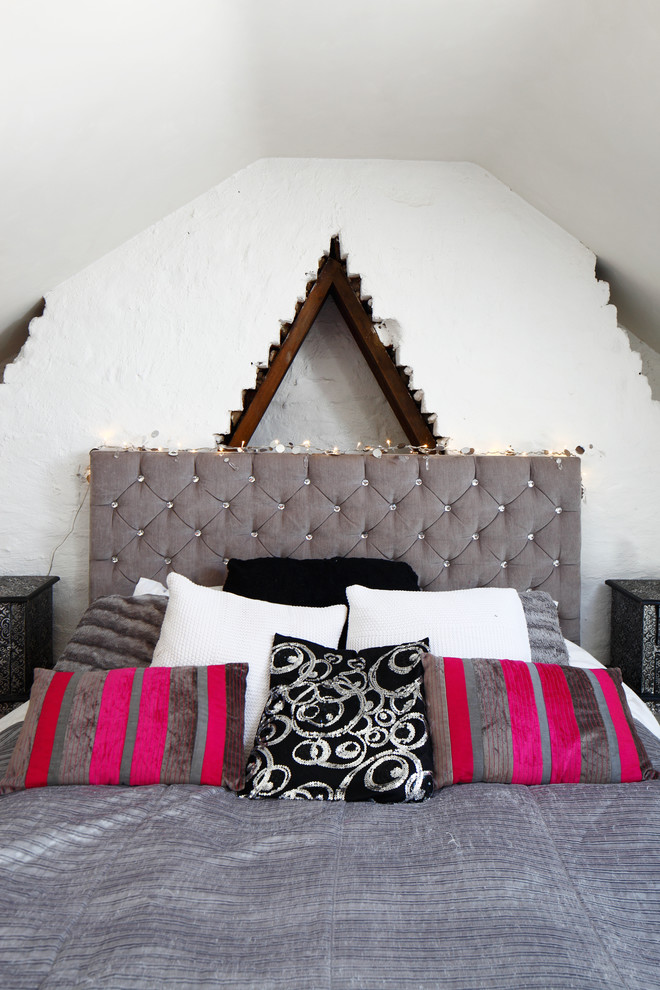 サセックスにある中くらいなエクレクティックスタイルのおしゃれな客用寝室 (白い壁、カーペット敷き、標準型暖炉、レンガの暖炉まわり、グレーの床)