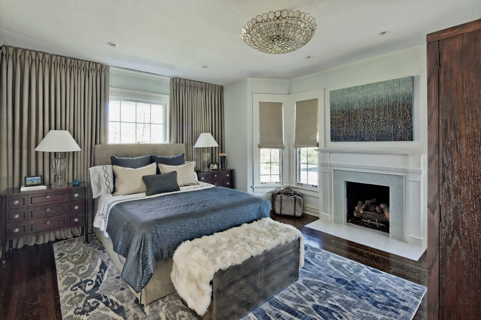 Стильный дизайн: большая хозяйская спальня в классическом стиле с серыми стенами, темным паркетным полом, стандартным камином и фасадом камина из плитки - последний тренд