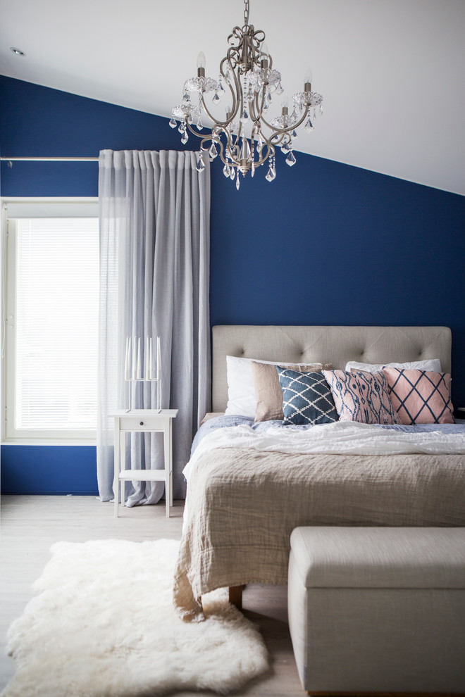 Bild på ett vintage sovrum, med blå väggar och ljust trägolv