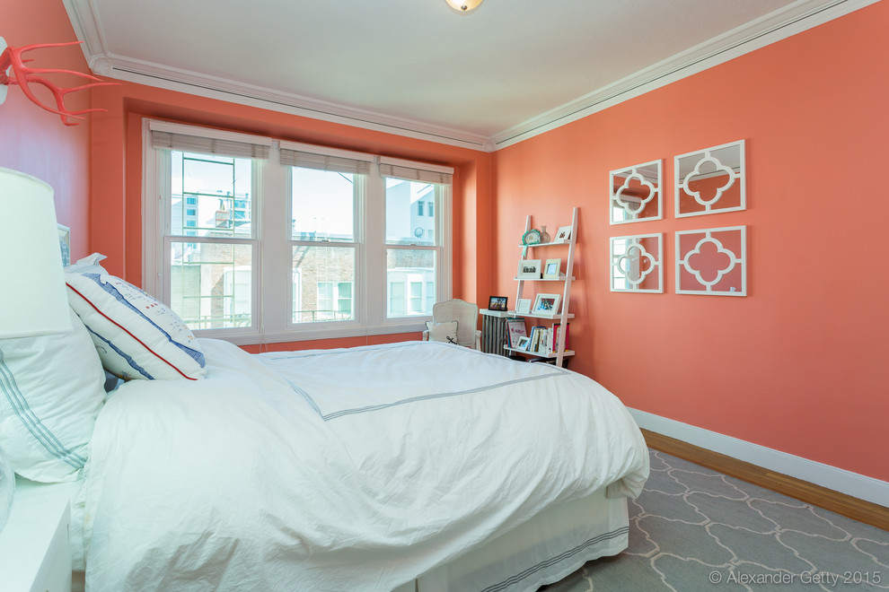 Modelo de dormitorio principal tradicional de tamaño medio con paredes rojas y suelo de madera en tonos medios