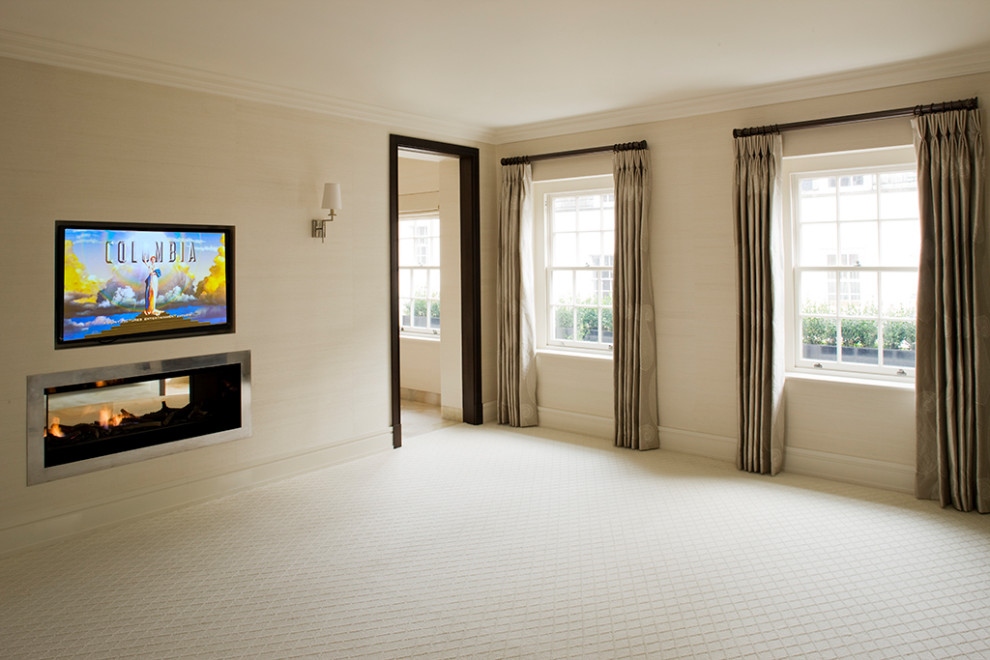 Exemple d'une grande chambre tendance avec un mur beige, une cheminée double-face, un manteau de cheminée en métal et un sol beige.