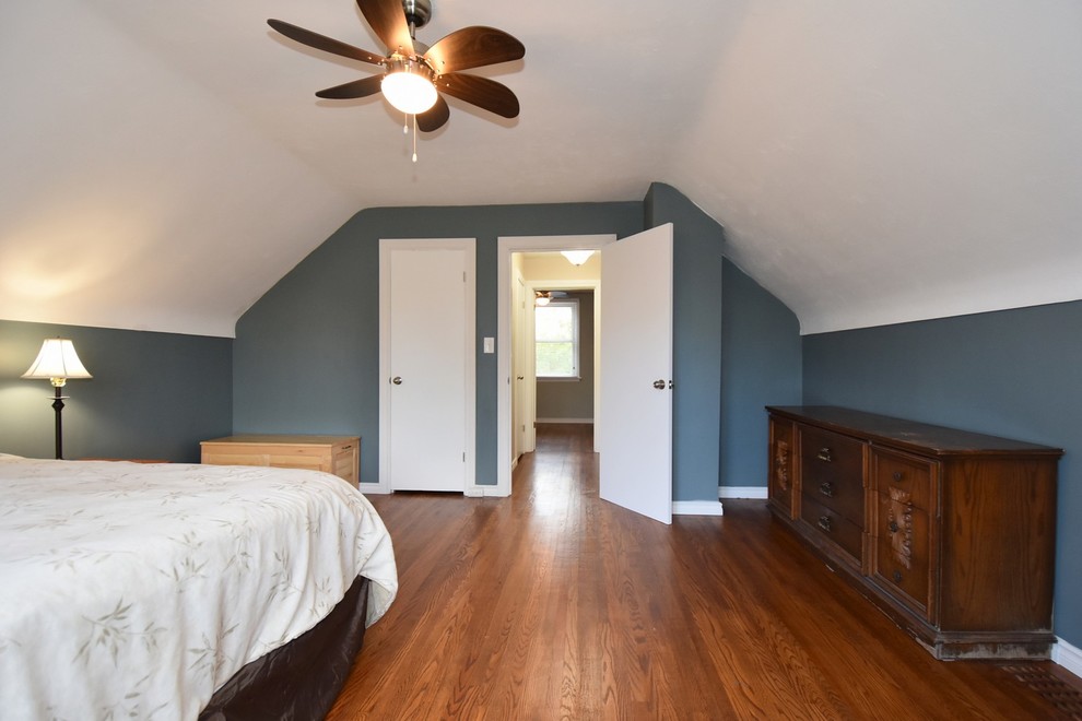 На фото: большая хозяйская спальня в стиле неоклассика (современная классика) с синими стенами и темным паркетным полом без камина с