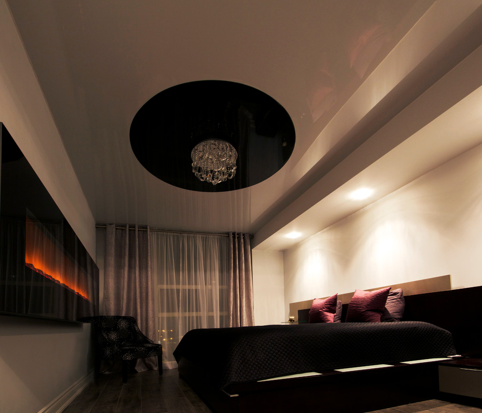 Diseño de dormitorio principal actual de tamaño medio con paredes blancas, suelo de madera oscura y chimenea lineal