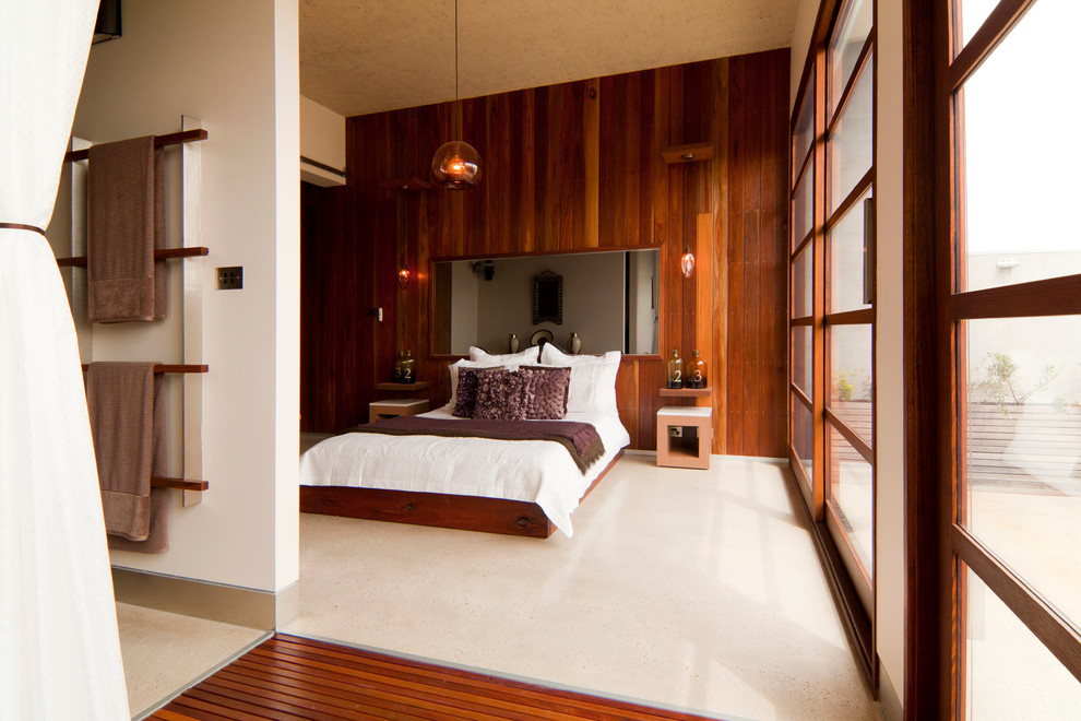 Diseño de dormitorio actual grande con paredes blancas y suelo de cemento