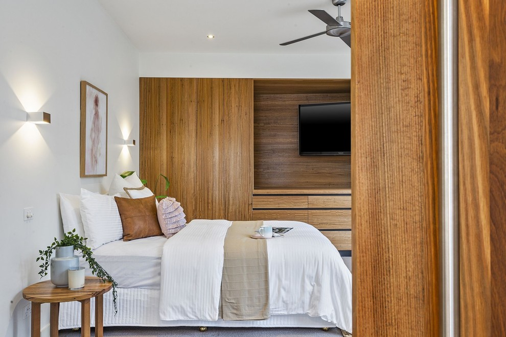 Contemporary bedroom in Geelong with white walls, carpet and grey floors.