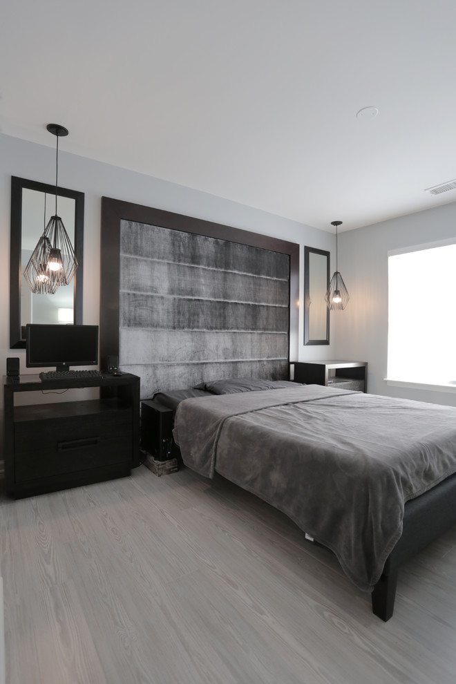 Идея дизайна: хозяйская спальня среднего размера в современном стиле с серыми стенами, полом из ламината и серым полом