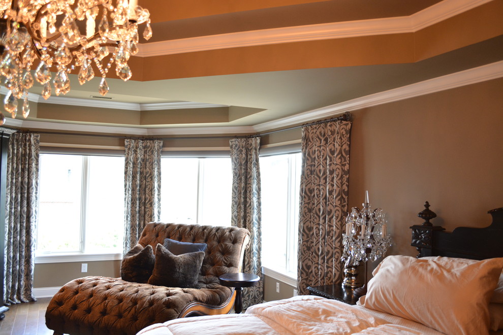 Idée de décoration pour une grande chambre parentale tradition avec un mur beige et un sol en bois brun.