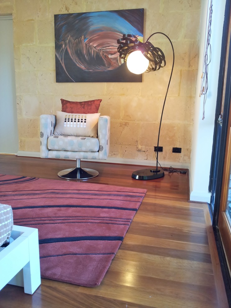 パースにある広いインダストリアルスタイルのおしゃれな客用寝室 (ベージュの壁、濃色無垢フローリング、標準型暖炉、石材の暖炉まわり、赤い床) のインテリア