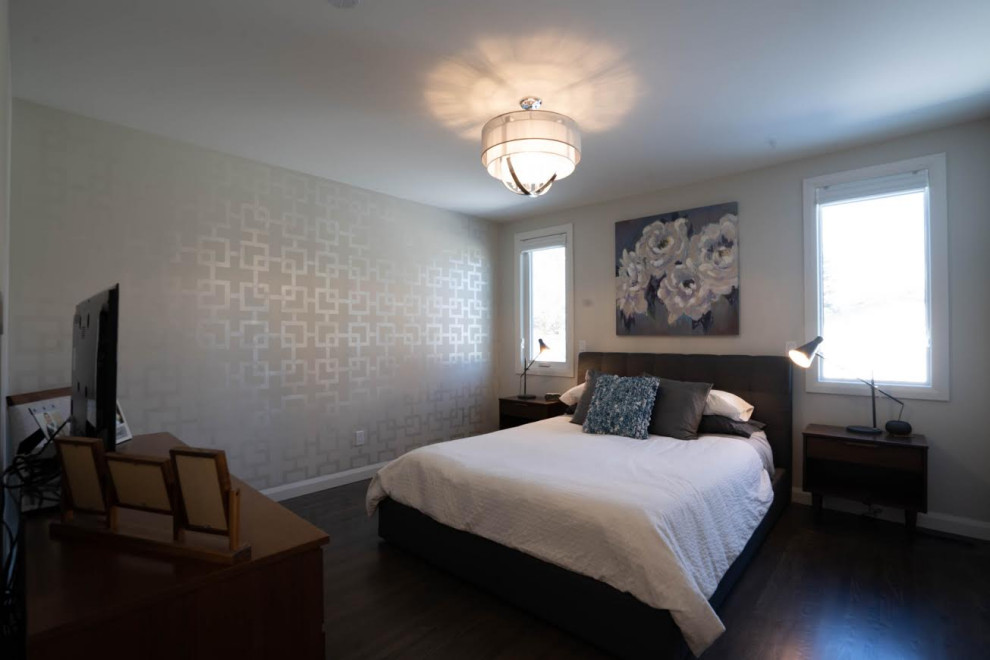 Cette photo montre une grande chambre d'amis rétro avec un mur gris, parquet foncé et un sol marron.