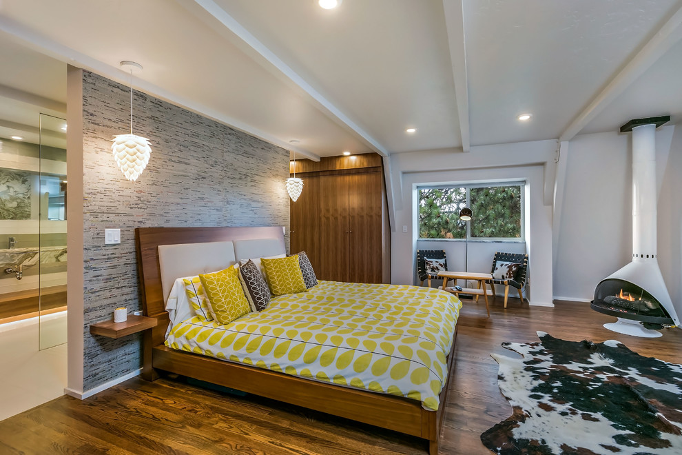 Idee per una camera matrimoniale minimal con pareti bianche, pavimento in legno massello medio e stufa a legna