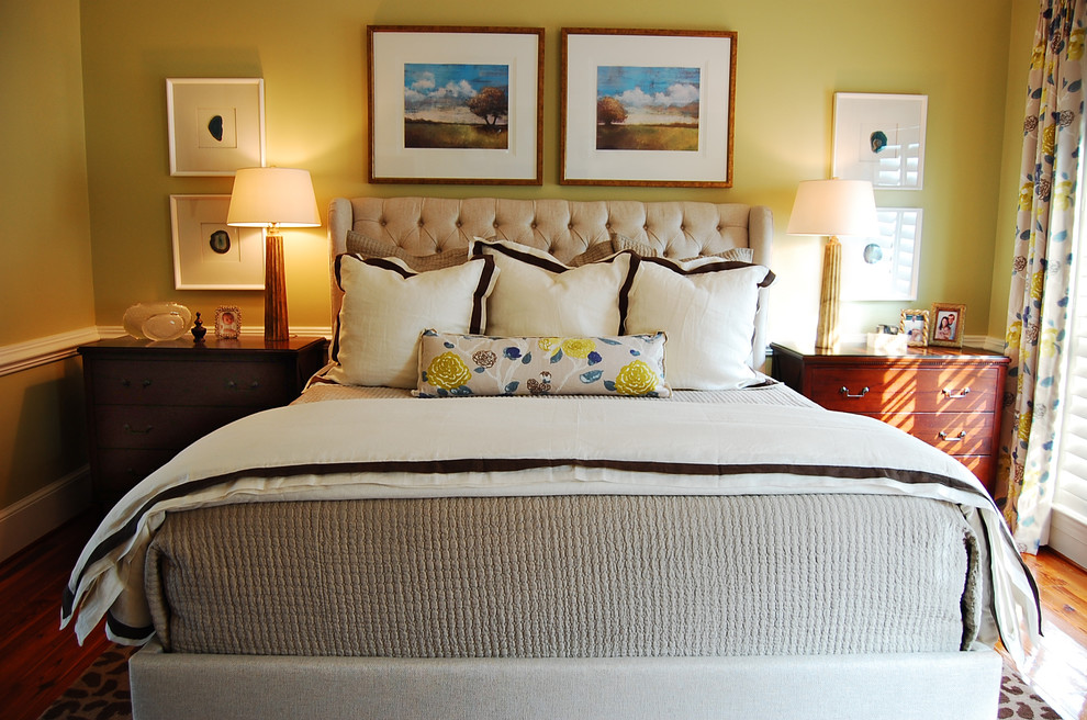 Ejemplo de dormitorio principal bohemio de tamaño medio sin chimenea con paredes amarillas, suelo de madera en tonos medios y suelo marrón