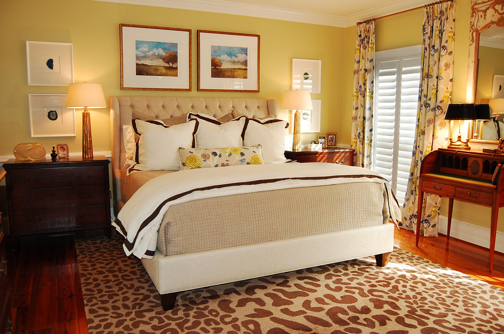 Imagen de dormitorio principal bohemio de tamaño medio sin chimenea con paredes amarillas, suelo de madera en tonos medios y suelo marrón