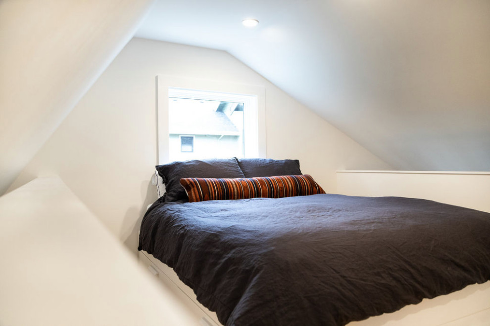 Diseño de dormitorio tipo loft actual pequeño con paredes blancas y suelo de madera clara