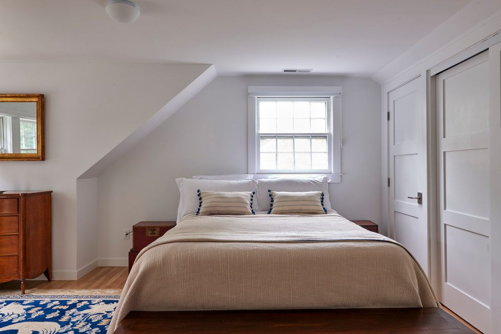 Imagen de dormitorio principal actual de tamaño medio con paredes blancas, suelo de madera clara y suelo marrón
