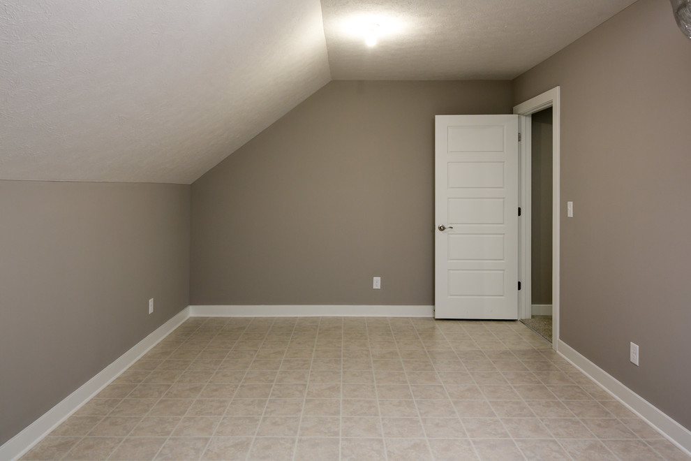 Imagen de dormitorio de estilo americano de tamaño medio con paredes grises, suelo laminado y suelo beige