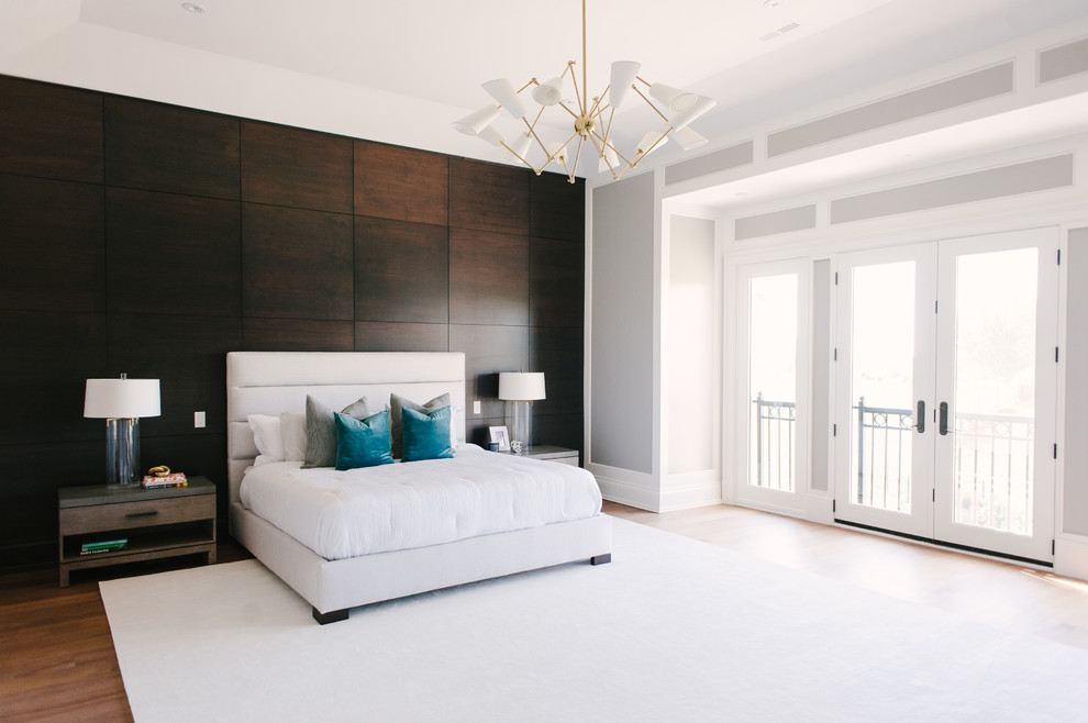 Large trendy master medium tone wood floor and brown floor bedroom photo in Toronto with gray walls