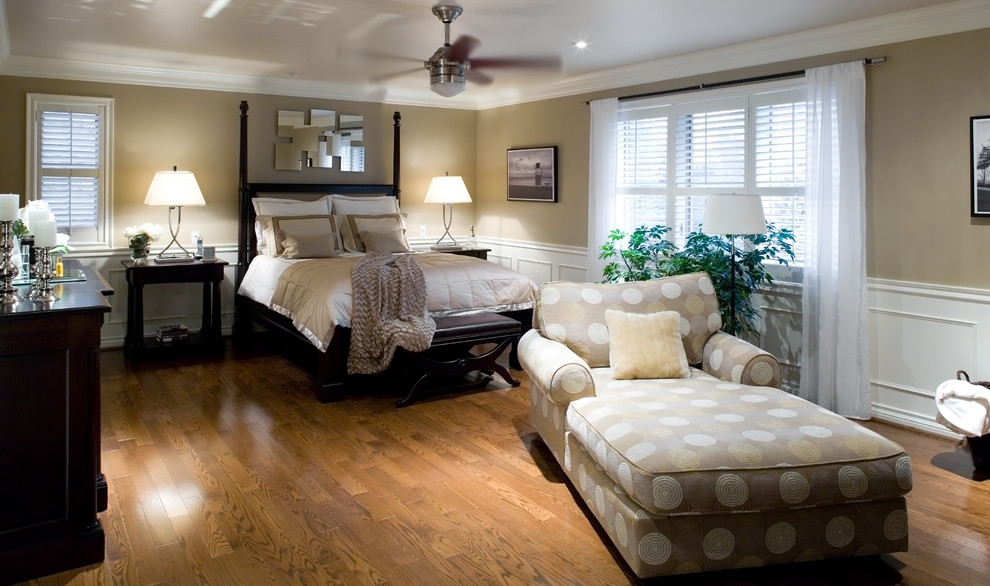 Foto de dormitorio principal tradicional grande sin chimenea con paredes beige y suelo de madera en tonos medios