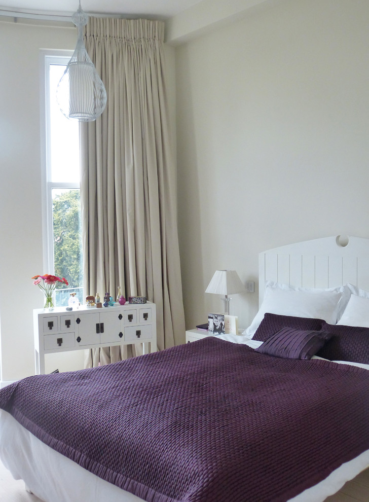 Modernes Hauptschlafzimmer ohne Kamin mit beiger Wandfarbe und hellem Holzboden in London
