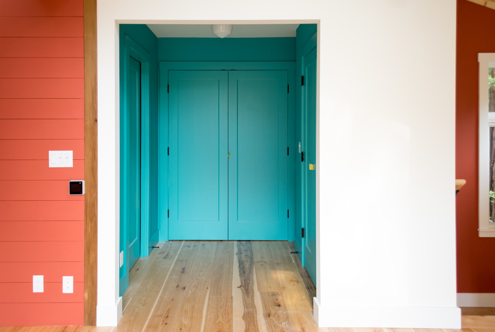 Mittelgroßes Modernes Hauptschlafzimmer ohne Kamin mit oranger Wandfarbe, hellem Holzboden und braunem Boden in San Francisco