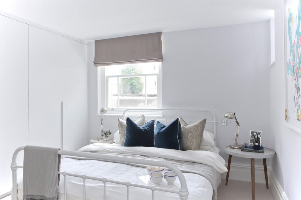 На фото: большая хозяйская спальня: освещение в скандинавском стиле с белыми стенами, ковровым покрытием и бежевым полом
