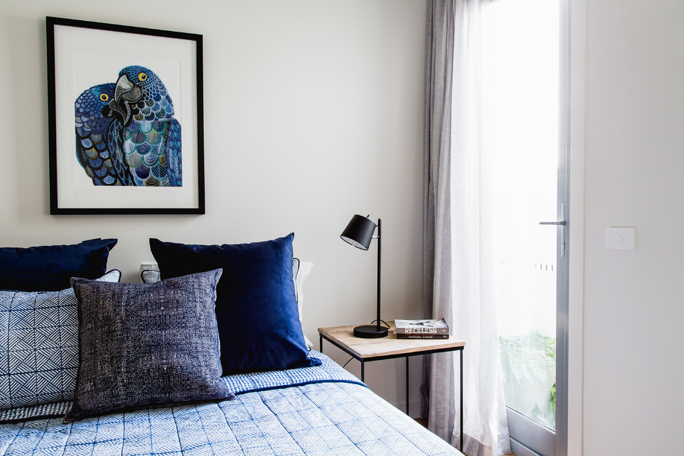 Inspiration for a medium sized contemporary guest bedroom in Melbourne with white walls and light hardwood flooring.