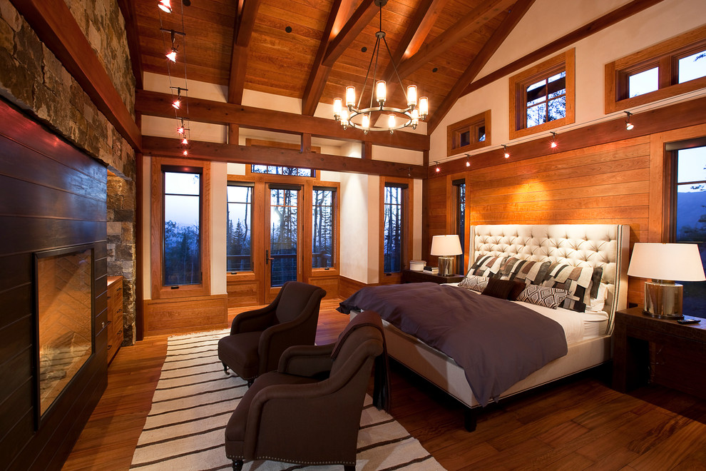 Mittelgroßes Uriges Hauptschlafzimmer mit gelber Wandfarbe, dunklem Holzboden, Kamin und Kaminumrandung aus Metall in Denver