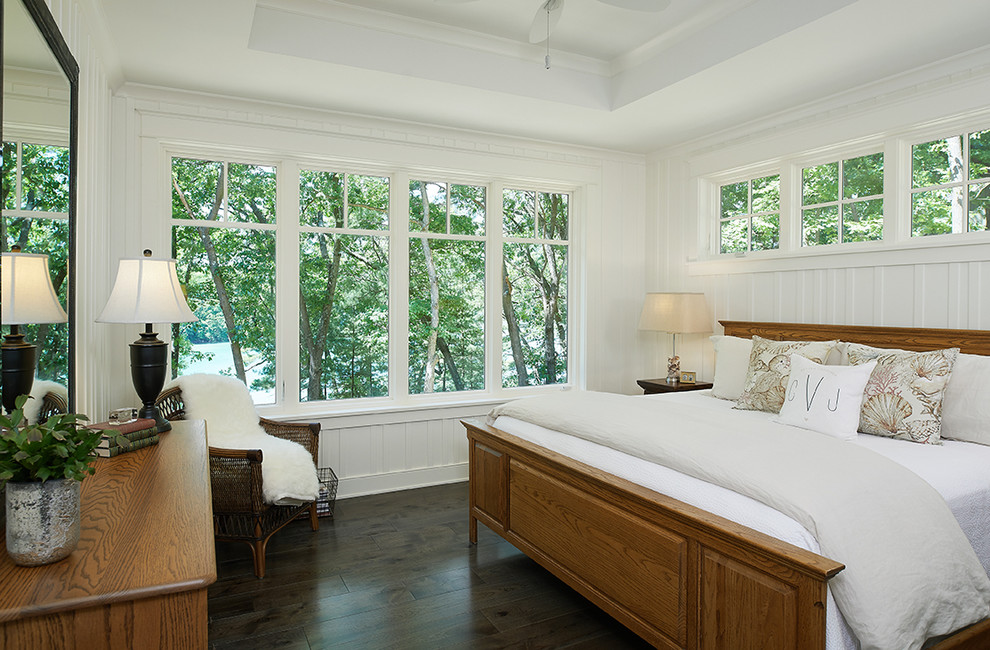 Exemple d'une chambre parentale tendance avec un mur blanc, parquet foncé et un sol marron.