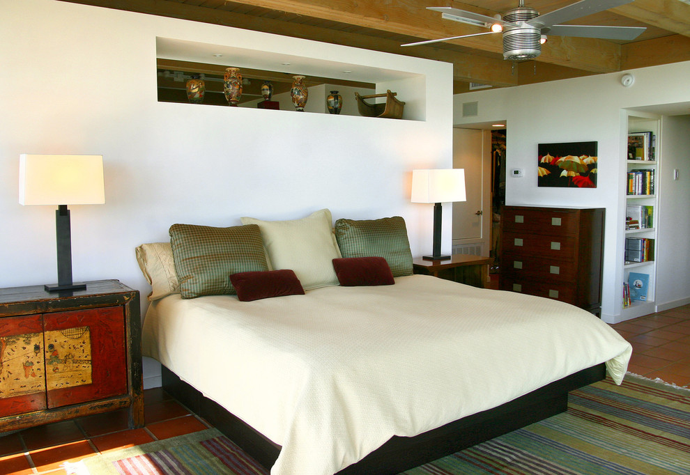 Imagen de dormitorio principal de estilo zen de tamaño medio sin chimenea con paredes blancas y suelo de baldosas de terracota
