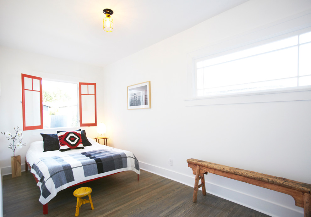 Imagen de dormitorio bohemio con paredes blancas y suelo de madera oscura