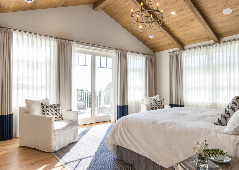 Ejemplo de dormitorio abovedado marinero con paredes blancas, suelo de madera en tonos medios, suelo marrón, vigas vistas y madera
