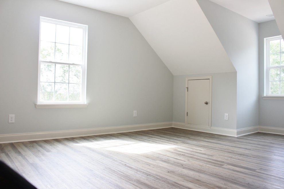 Modelo de habitación de invitados de estilo americano de tamaño medio con paredes grises, suelo vinílico y suelo gris