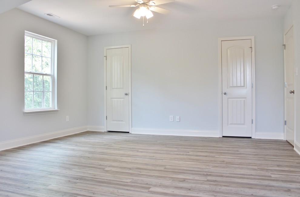 Ejemplo de dormitorio principal de estilo americano de tamaño medio con paredes grises, suelo vinílico y suelo gris