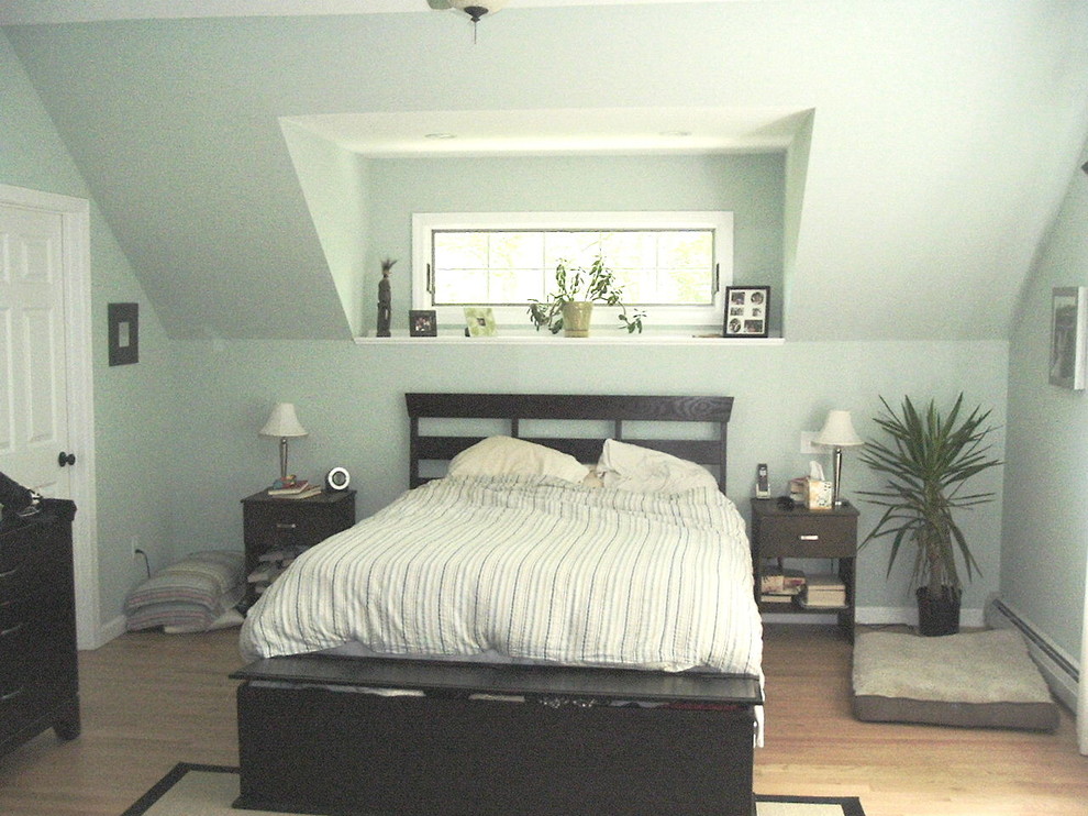 This is an example of a medium sized rural master bedroom in Bridgeport with beige walls and light hardwood flooring.