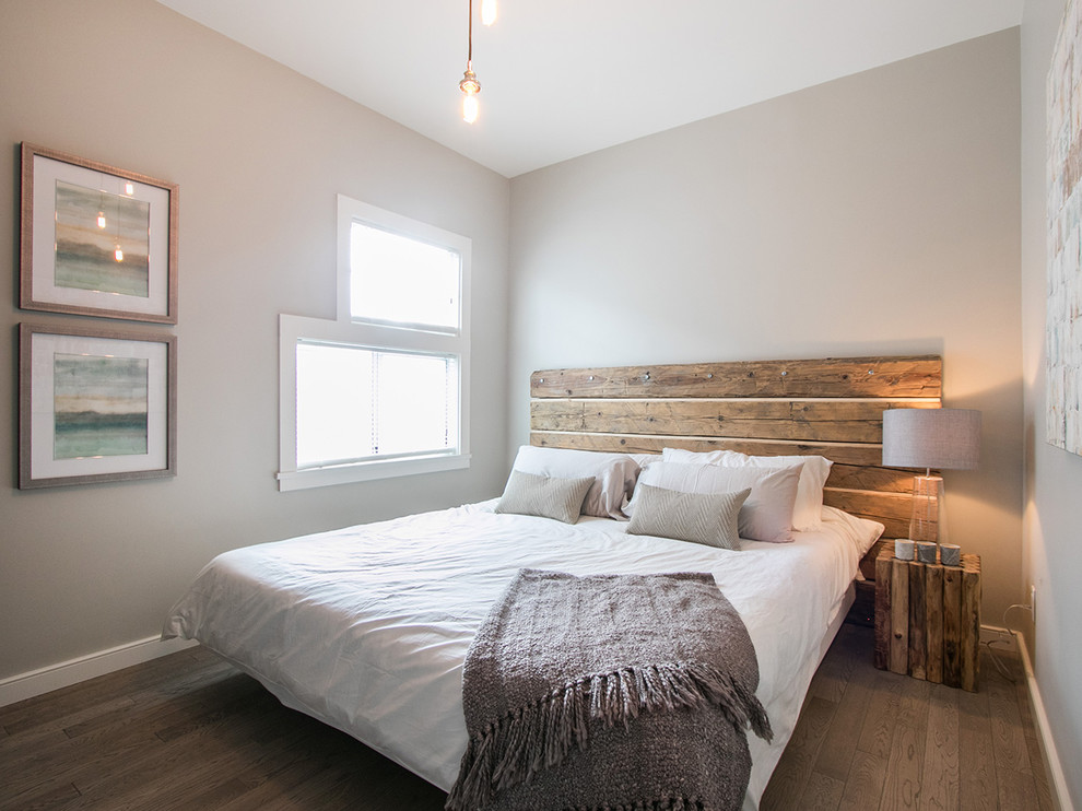 Photo of a small farmhouse master bedroom in Vancouver with light hardwood flooring, grey walls and feature lighting.