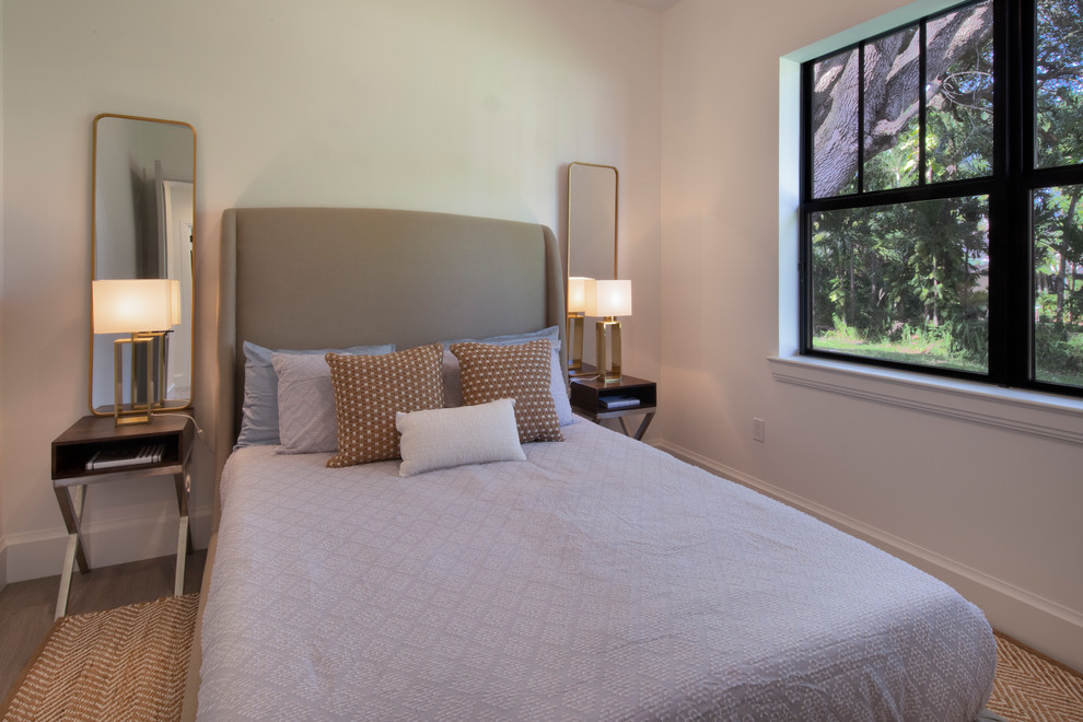 Immagine di una piccola camera degli ospiti contemporanea con pareti beige, parquet chiaro e pavimento marrone