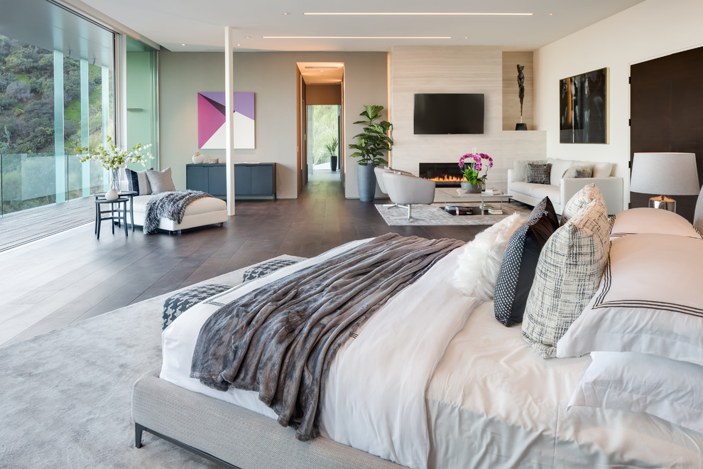 Modernes Schlafzimmer mit beiger Wandfarbe, dunklem Holzboden, Kamin und braunem Boden in Los Angeles