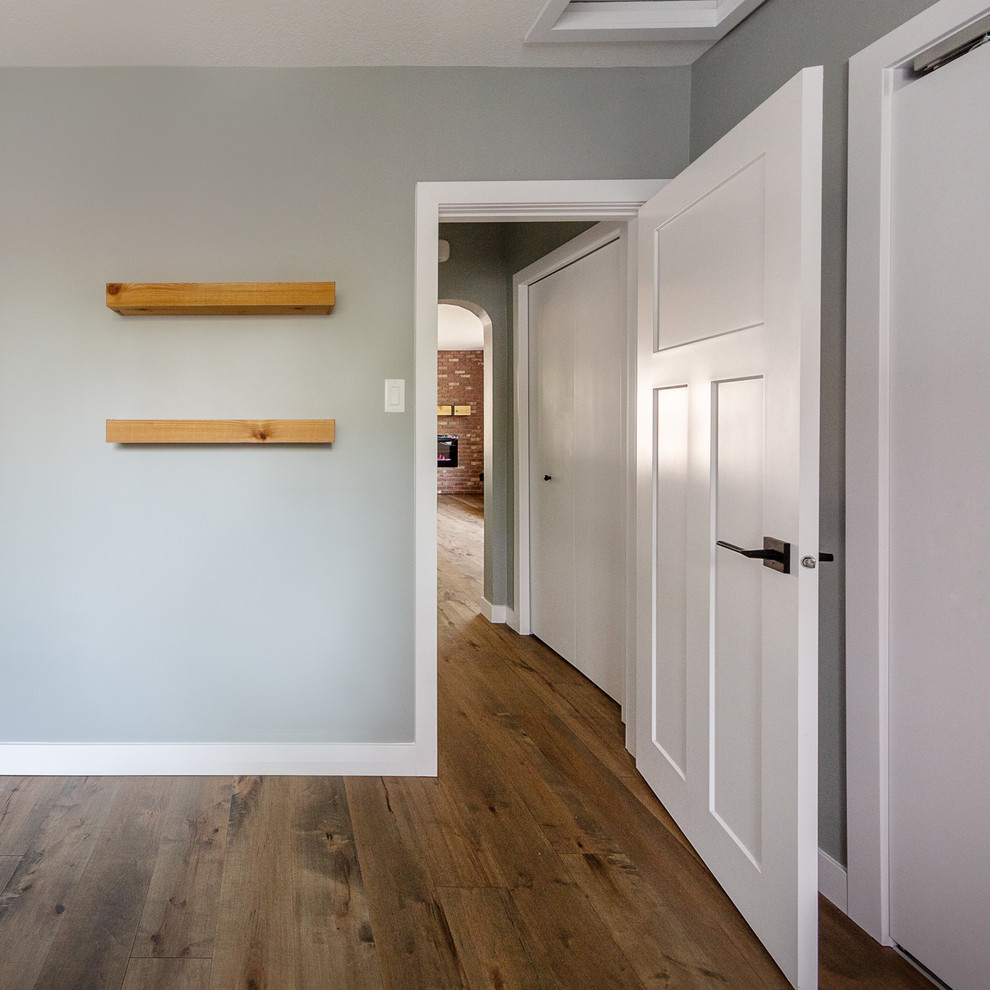 Kleines Industrial Hauptschlafzimmer mit grauer Wandfarbe, braunem Holzboden und braunem Boden in Edmonton
