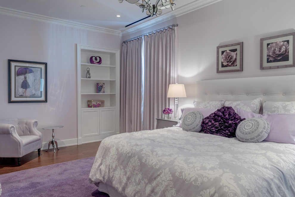 Cette image montre une grande chambre parentale traditionnelle avec un mur violet et un sol en bois brun.