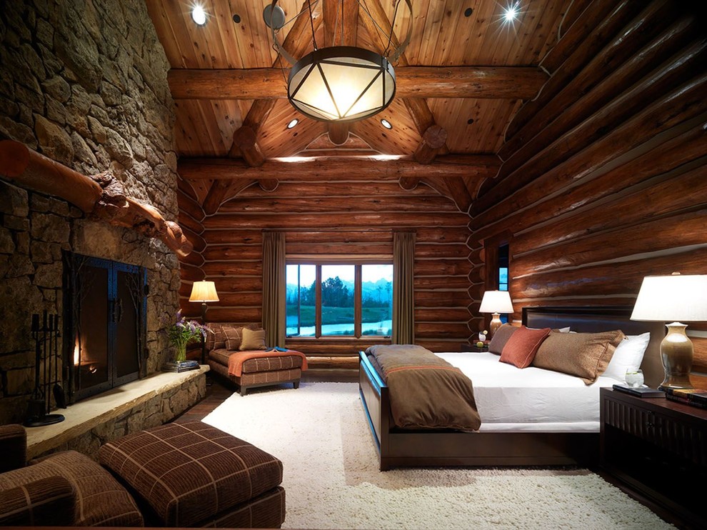 Medium sized rustic master bedroom in Other with a standard fireplace, brown walls, dark hardwood flooring, a stone fireplace surround and brown floors.
