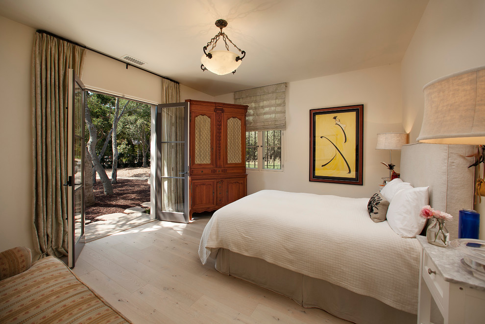 Ejemplo de habitación de invitados mediterránea grande con paredes beige y suelo de madera clara