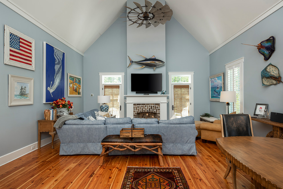 Cette photo montre une petite chambre d'amis chic avec un mur bleu, parquet clair, une cheminée standard, un manteau de cheminée en bois et un sol marron.