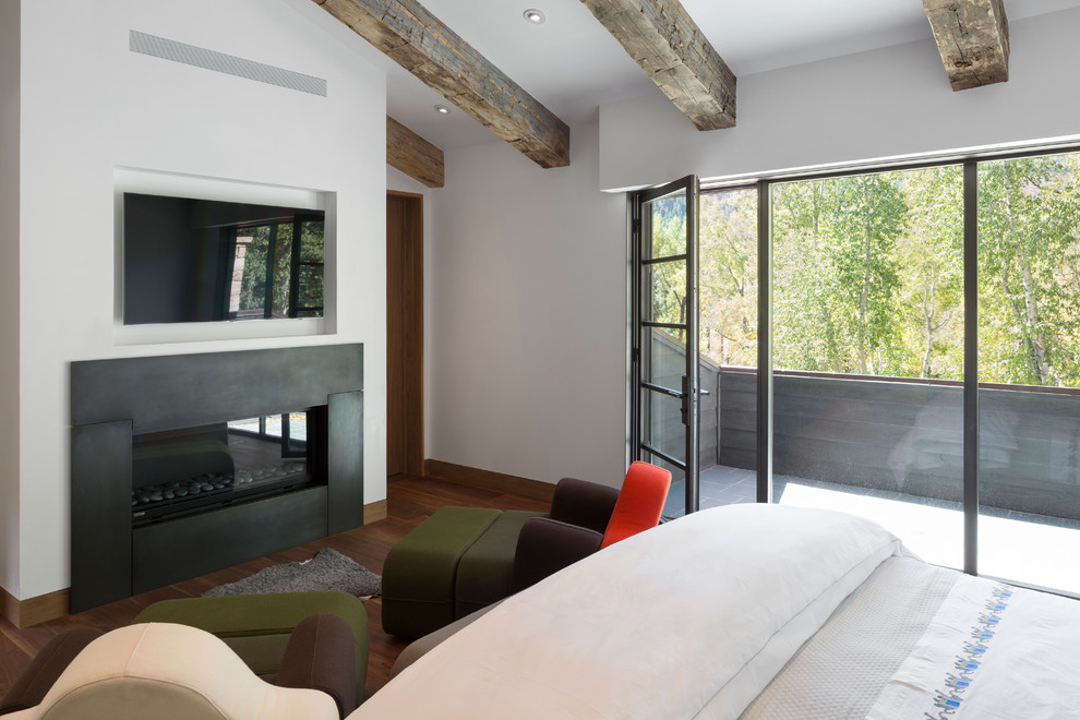 Großes Modernes Hauptschlafzimmer mit weißer Wandfarbe, braunem Holzboden, Gaskamin und Kaminumrandung aus Metall in Denver
